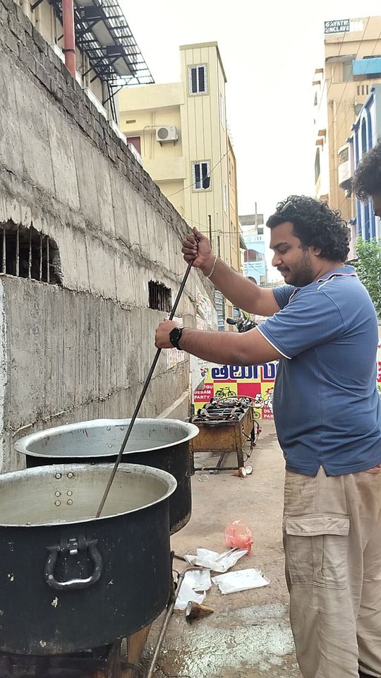 Kadali Venkatesh stirring a large pot of food for the Annadanam